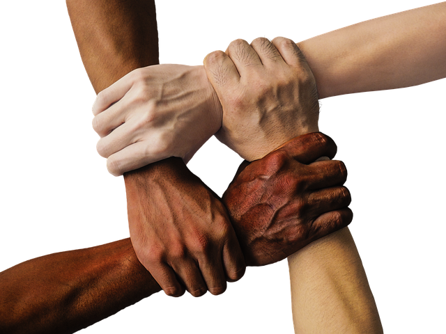 Diversified hands clasped on each other's wrists together in unity